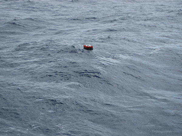 A commemorative wreath floating on the surface of the ocean.