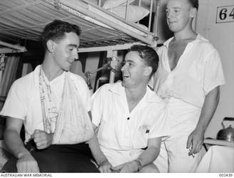 ABOARD HMAS SYDNEY THE ONLY CASUALTY IN THE SUCCESSFUL ACTION AGAINST THE ITALIAN CRUISER BARTOLOMEO COLLEONI, ABLE SEAMAN D. THOMPSON (LEFT), WITH LEADING SICK BAY ATTENDANT C.J. WILSON AND SICK BAY ATTENDANT D.E. SHELLEY.