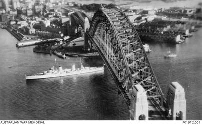 Sydney, NSW. c. 1938. Aerial port view of the cruiser HMAS Sydney (II). The Sydney has just passed under the Sydney Harbour Bridge. (Donor K. Otton)