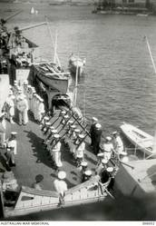 ALEXANDRIA, EGYPT. 1940-07-24. THE FUNERAL FIRING PARTY GOING ASHORE TO PARTICIPATE IN THE BURIAL OF THE CAPTAIN OF THE ITALIAN CRUISER BARTOLOMEO COLLEONI, SUNK BY HMAS SYDNEY (II) SEVERAL DAYS PREVIOUSLY. (NAVAL HISTORICAL COLLECTION).