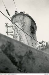 DAMAGE TO THE FORWARD FUNNEL OF THE CRUISER HMAS SYDNEY (II) AFTER BEING HIT BY A 6 INCH SHELL FROM THE ITALIAN CRUISER BARTOLOMEO COLLEONI DURING THE ACTION OFF CAPE SPADA, CRETE. (NAVAL HISTORICAL COLLECTION).
