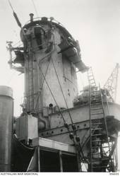 ALEXANDRIA, EGYPT. 1940-07-22. EGYPTIAN WORKMEN CARRYING OUT REPAIRS TO THE FORWARD FUNNEL ON HMAS SYDNEY (II) AFTER IT WAS DAMAGED IN THE CAPE SPADA ACTION AGAINST THE ITALIAN CRUISER THE BARTOLOMEO COLLEONI. (NAVAL HISTORICAL COLLECTION).