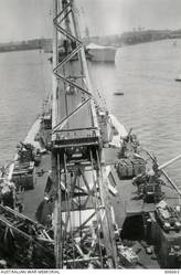 ALEXANDRIA, EGYPT. 1940-07-20. VIEW FROM THE FUNNEL ON BOARD THE CRUISER HMAS SYDNEY (II) LOOKING AFT. IN THE FOREGROUND IS THE AIRCRAFT HANDLING CRANE BENEATH WHICH IS THE CATAPULT. THE SHIP'S FOUR 4 INCH MARK V AA GUNS ARE VISIBLE WITH THEIR READY USE AMMUNITION LOCKERS BETWEEN THEM. IN THE BACKGROUND IS THE FRENCH CRUISER DUGUAY-TROUIN. (NAVAL HISTORICAL COLLECTION).