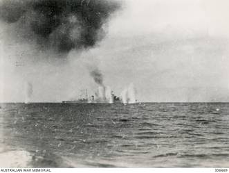 STOPPED AND ON FIRE AFTER THE ACTION OFF CAPE SPADA WITH HMAS SYDNEY (II) AND BRITISH DESTROYERS THE ITALIAN NAVY CRUISER BARTOLOMEO COLLEONI IS SURROUNDED BY SHELL SPLASHES AS SHE AWAITS THE COUP DE GRACE. (NAVAL HISTORICAL COLLECTION).