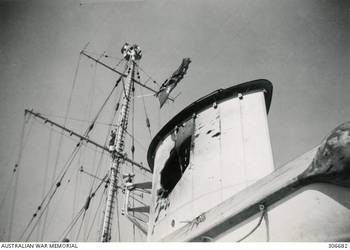 DAMAGE TO THE FORWARD FUNNEL OF THE CRUISER HMAS SYDNEY (II) AFTER BEING HIT BY A 6 INCH SHELL FROM THE ITALIAN CRUISER BARTOLOMEO COLLEONI DURING THE ACTION OFF CAPE SPADA. (NAVAL HISTORICAL COLLECTION).