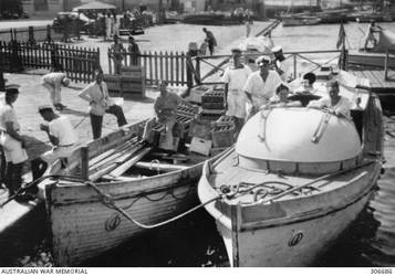 ALEXANDRIA, EGYPT. 1940-07-20. THE MOTOR BOAT AND CUTTER OF THE CRUISER HMAS SYDNEY (II) ALONGSIDE NO. 6 QUAY. THEY ARE BRINGING PART OF THE LARGE QUANTITY OF BEER BACK TO THE SHIP FOR THE OFFICERS TO CELEBRATE THE SUCCESS OF THE ACTION OFF CAPE SPADA THE PREVIOUS DAY. (NAVAL HISTORICAL COLLECTION).