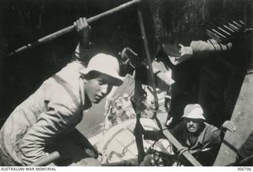 ALEXANDRIA, EGYPT. 1940-07-20. EGYPTIAN WORKMEN REPAIRING DAMAGE TO THE FORWARD FUNNEL OF HMAS SYDNEY (II) CAUSED BY A HIT FROM A 6 INCH SHELL FROM THE ITALIAN CRUISER BARTOLOMEO COLLEONI DURING THE ACTION OFF CAPE SPADE, CRETE. THE PHOTOGRAPH WAS TAKEN LOOKING DOWN THROUGH THE HOLE TO THE WATER ON THE PORT SIDE. (NAVAL HISTORICAL COLLECTION).