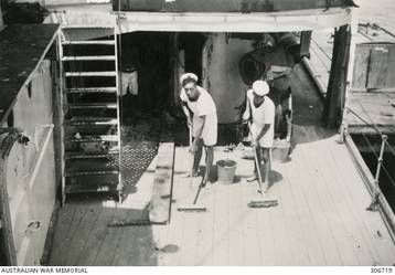 ALEXANDRIA, EGYPT. 1940-08-29. TWO SEAMEN, J. HORRIGAN AND B. CRAIKE, PAINTING THE DECK OF THE CRUISER HMAS SYDNEY (II) WITH BLUE DYE TO CAMOUFLAGE THE SHIP FROM ENEMY BOMBERS. (NAVAL HISTORICAL COLLECTION).