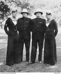 Outdoor group portrait of two Royal Australian Navy sailors and two Victorian police officers. Identified from left: 22630 Leading Stoker (Ldg Sto) Norman Francis Grinter, HMAS Sydney II, of Melbourne, Vic; his father, Francis Reginald Grinter, a Victorian Police Officer, who served with the 2nd Field Artillery Brigade during the First World War; unidentified; unidentified. Ldg Sto Grinter enlisted on 5 December 1938 and was killed in action on 20 November 1941, aged 23, when HMAS Sydney II was sunk in the Indian Ocean off the coast of Western Australia by the German raider, HSK Kormoran.