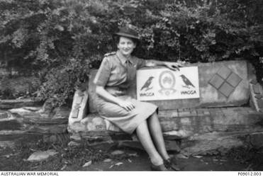 Informal outdoor portrait of NF410507 Signaller Ruth Gloria Tobin, Australian Special Wireless Group, Australian Womens Army Service, whilst serving at Bonegilla Camp, Victoria. Ruth Tobin had been the girlfriend of 23289 Stoker Francis Bernard Keenan who was killed in action, aged 25, when HMAS Sydney II was sunk in the Indian Ocean by the German auxiliary cruiser Kormoran on 20 November 1941. Following the sinking of the Sydney Ruth Tobin enlisted in the Australian Special Wireless Group where she worked as an enemy intercept 'kana' operator, trained to intercept and transcribe the katakana, the Japanese writing system used for morse code.