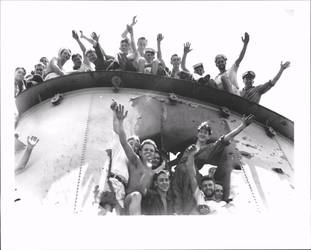 Sydney sailors waving atop and through a hole in the hull of a defeated ship
