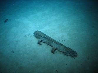 Wooden post with metal hinges. Possibly rudder post from boat